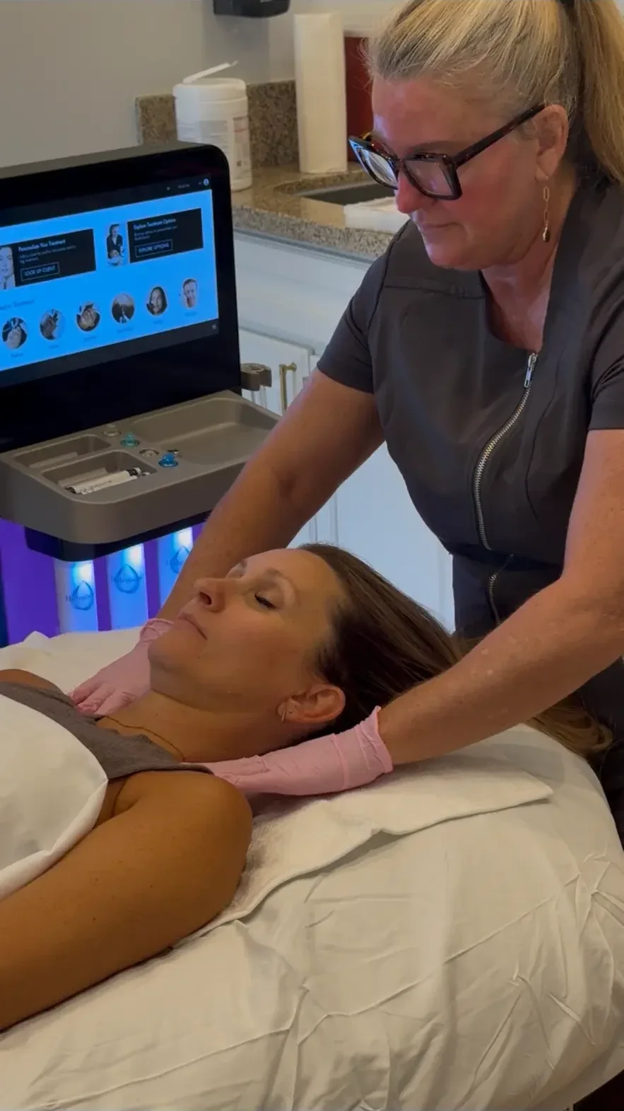 Provider reading a guest's skin at the HydraFacial device before beginning treatment